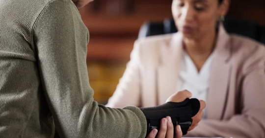 Man in brace talking to an attorney