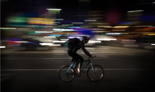 cyclist riding on the street at night