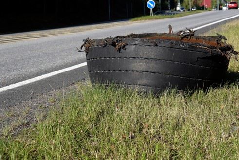 defective tire laying on side of road after accident